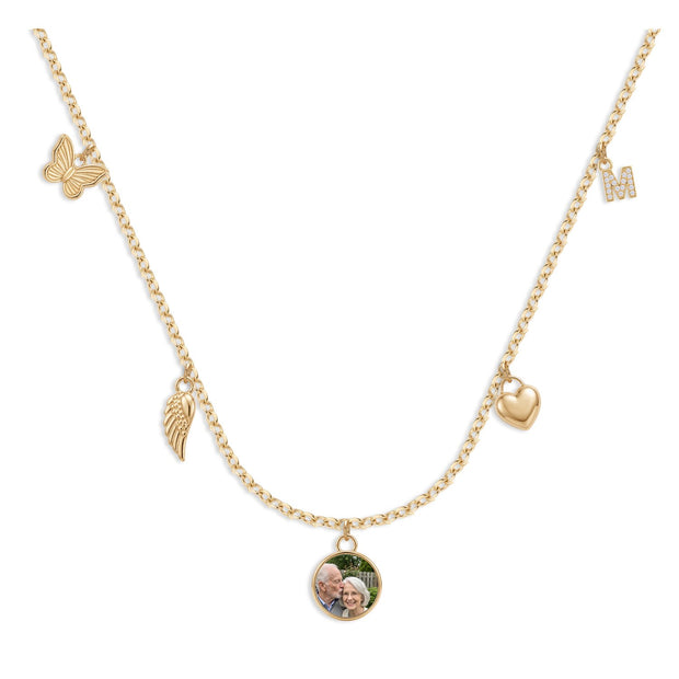 Mini charm necklace with a round photo charm in the center, a butterfly, an angel wing, a heart and an initial