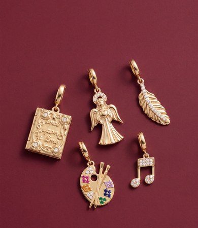 Gold storybook locket, guardian angel, feather, artist's palette and music note charms