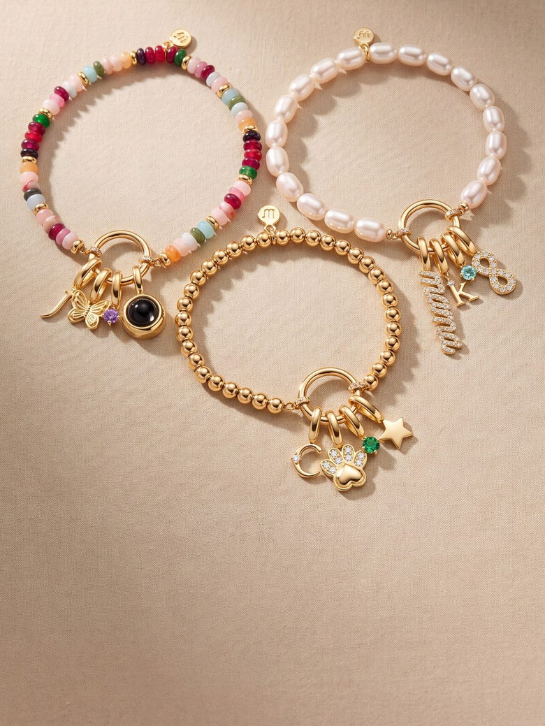 Three charm bracelets (colorful beads, pearls and gold beads), each with initial, birthstone and symbol charms